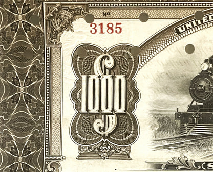Close-up of ornate antique bond certificate showing decorative "1000" denomination with steam locomotive