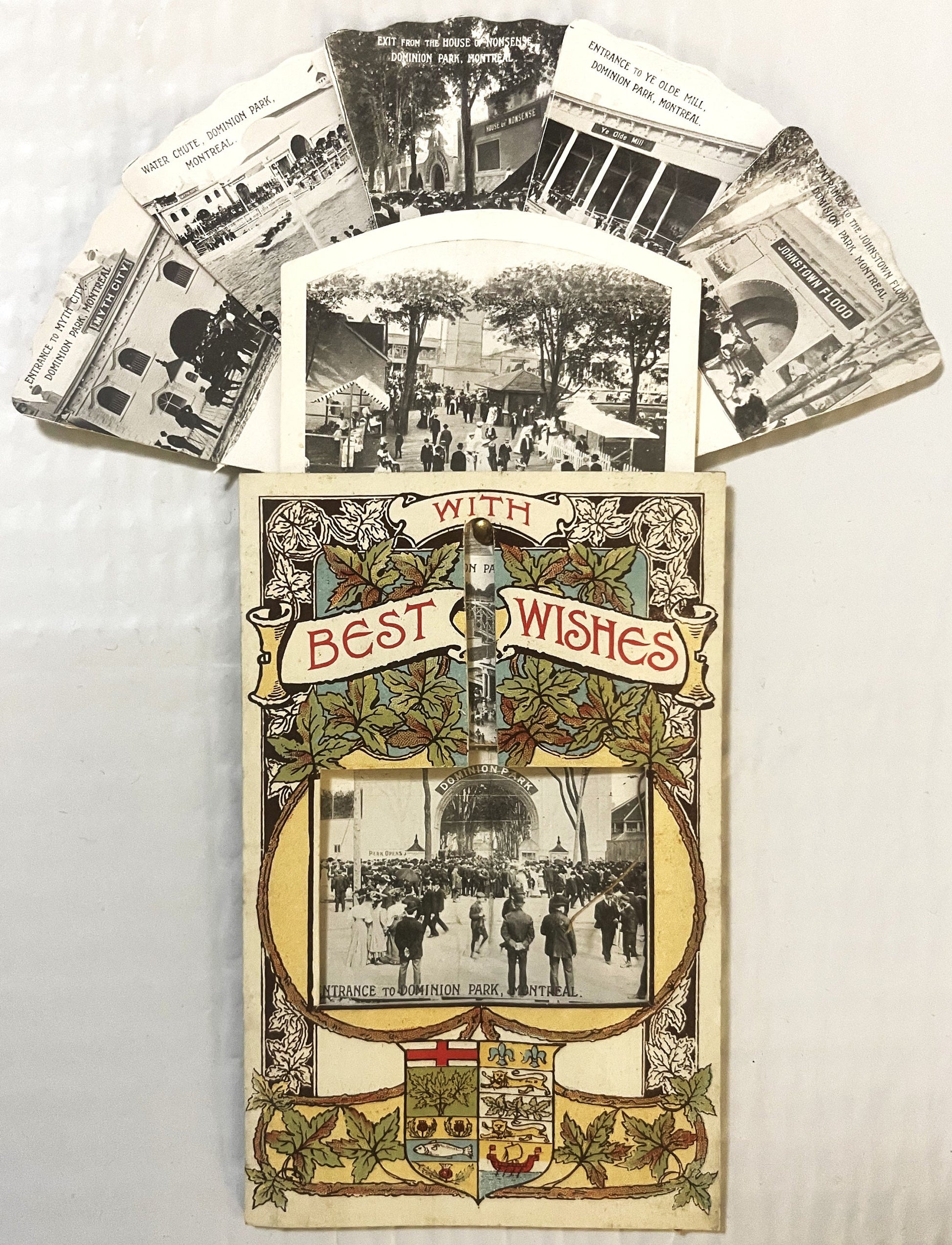 Vintage fan-shaped postcard with decorative art nouveau border, "With Best Wishes" banner, and central photo of crowded park 