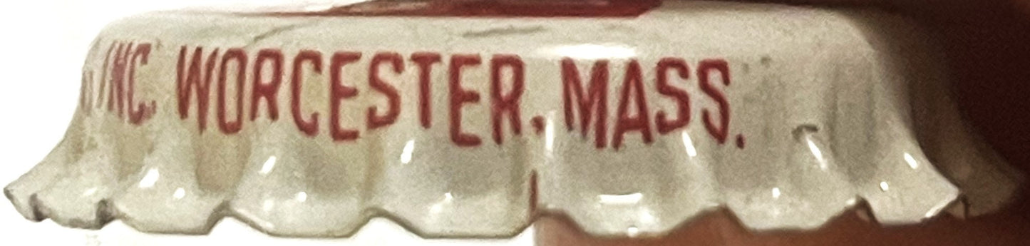 Close-up of cream-colored bottle cap with red embossed text reading "UNC WORCESTER, MASS" and scalloped edges, shown at angle