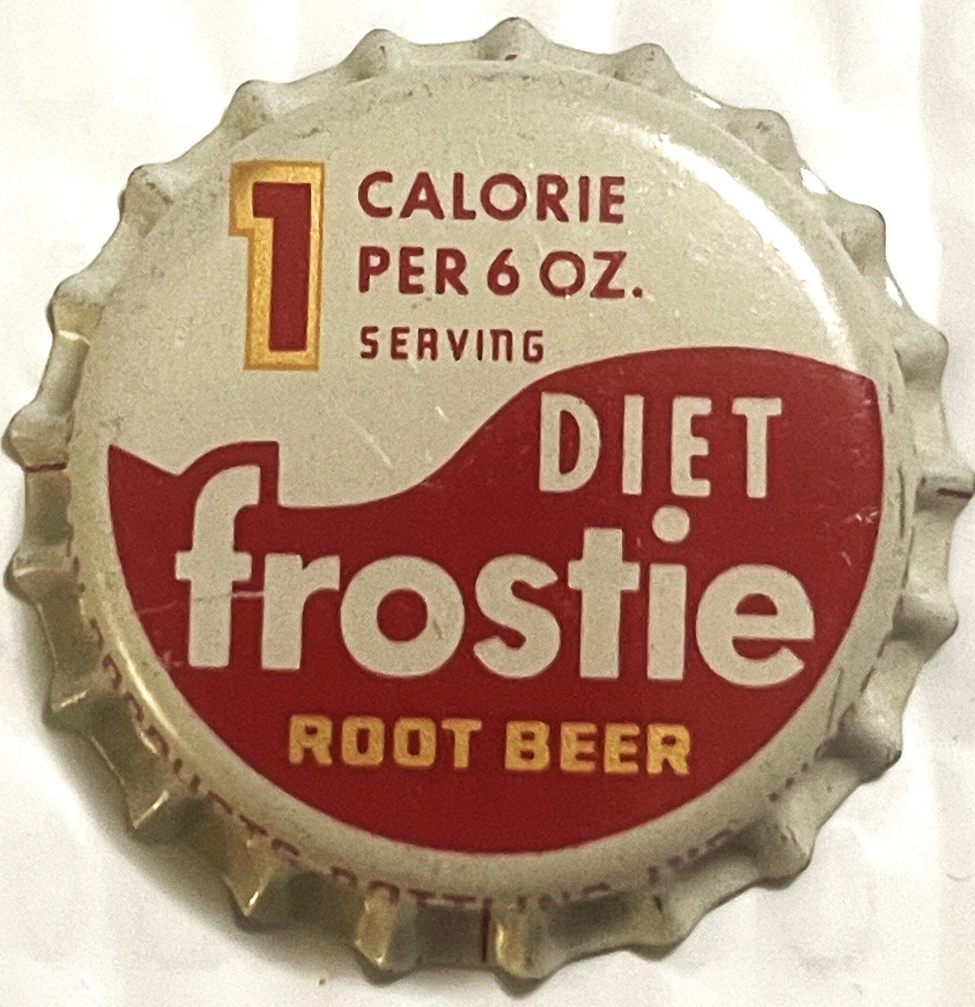 Vintage bottle cap with crimped metal edges, cream and dark red design, printed text reading "Diet Frostie Root Beer" and "1 