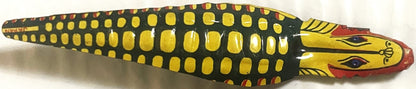 Vintage tin snake noisemaker with dark green body, yellow rounded spots, yellow head with red mouth and blue eyes, shown from