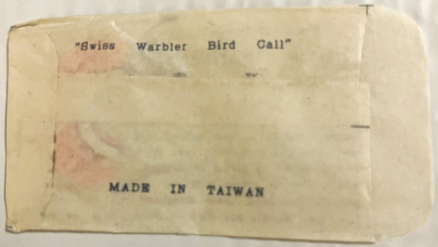 Cream-colored vintage box back with "Swiss Warbler Bird Call" and "Made in Taiwan" printed text, showing age discoloration an