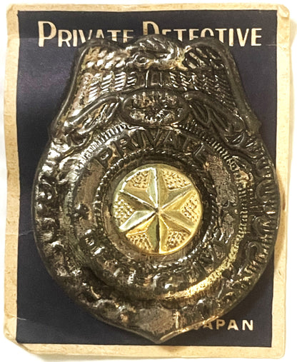 Vintage metal private detective badge with eagle emblem and gold star center on black card labeled "PRIVATE DETECTIVE" and "P