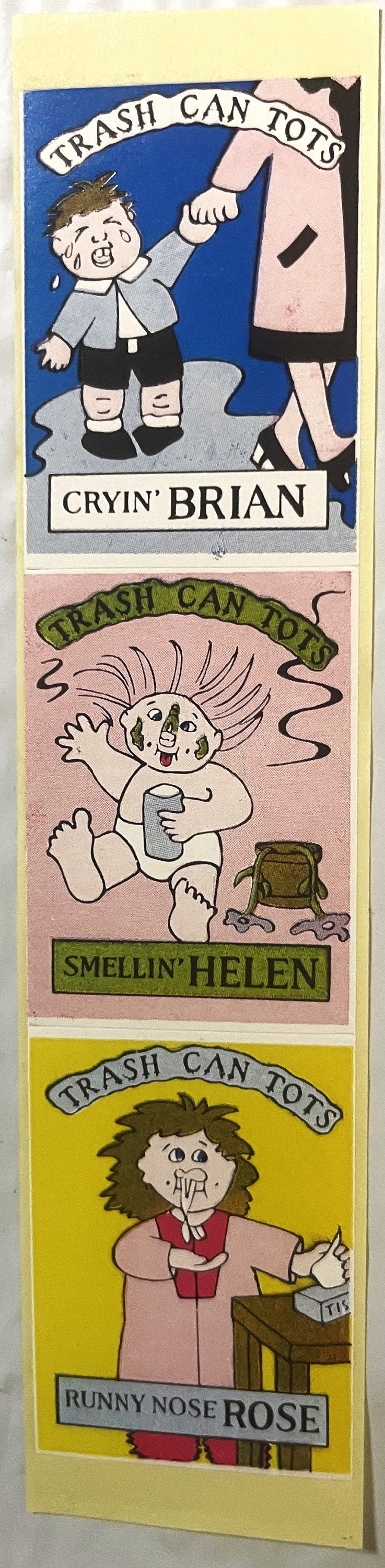 Three sticker panels labeled "Trash Can Tots" featuring cartoon characters: Cryin' Brian, Smellin' Helen, and Runny Nose Rose
