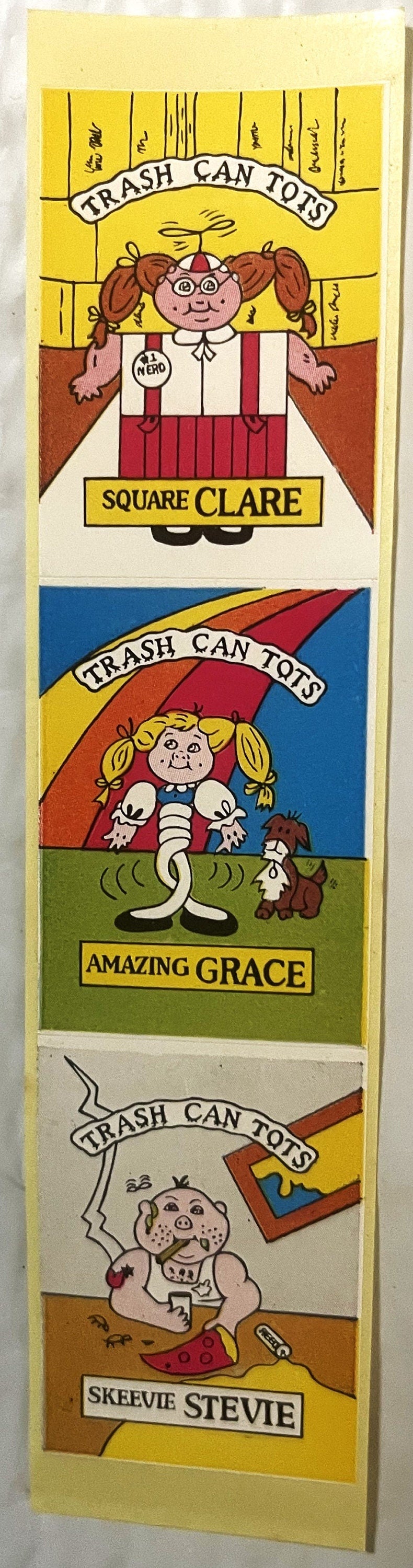 Three colorful sticker panels labeled "Trash Can Tots" featuring cartoon characters: Square Clare, Amazing Grace, and Skeevie