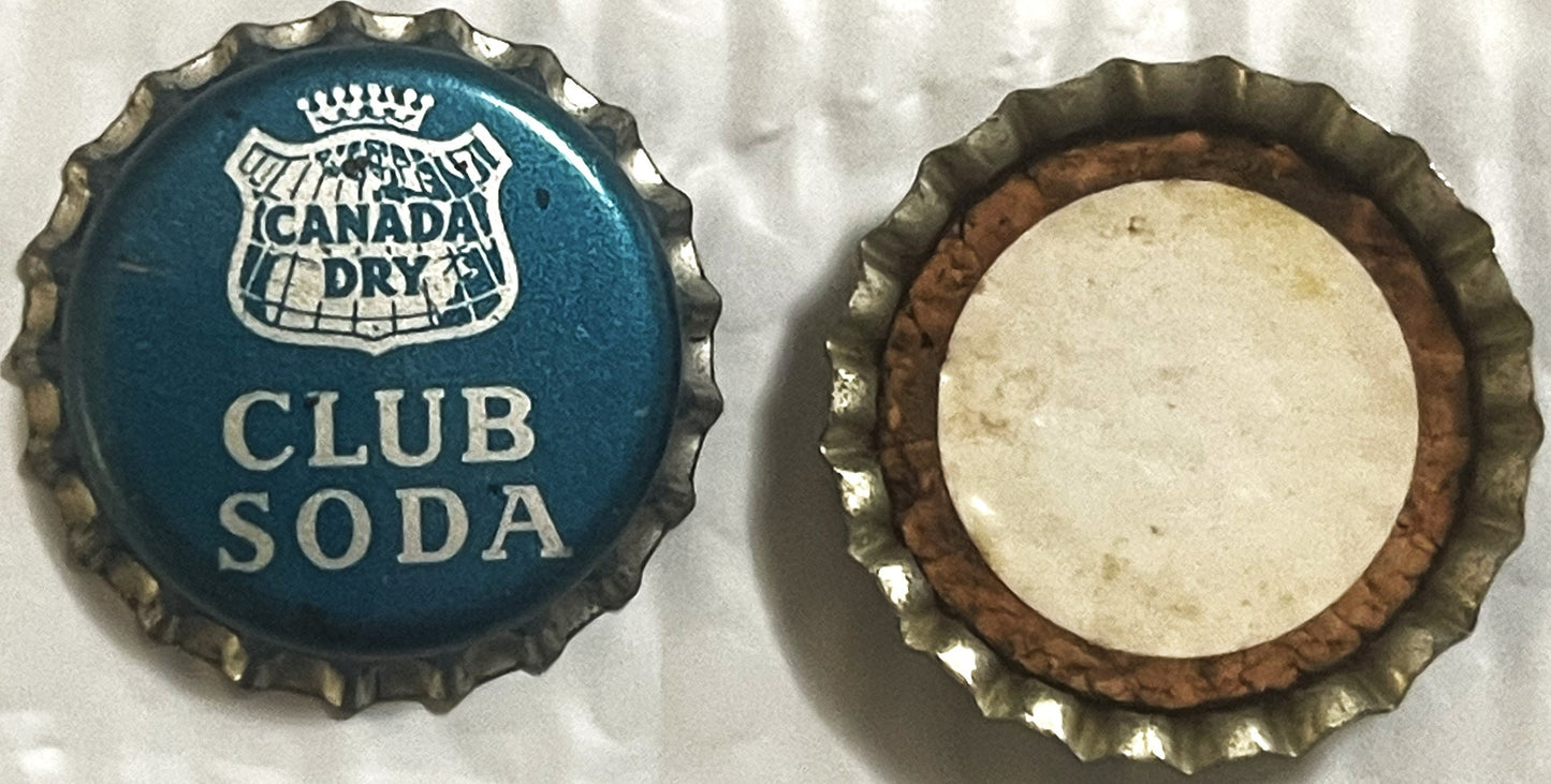 Two views of a Canada Dry Club Soda bottle cap: front showing blue crown logo and text, back showing cork lining in cream and