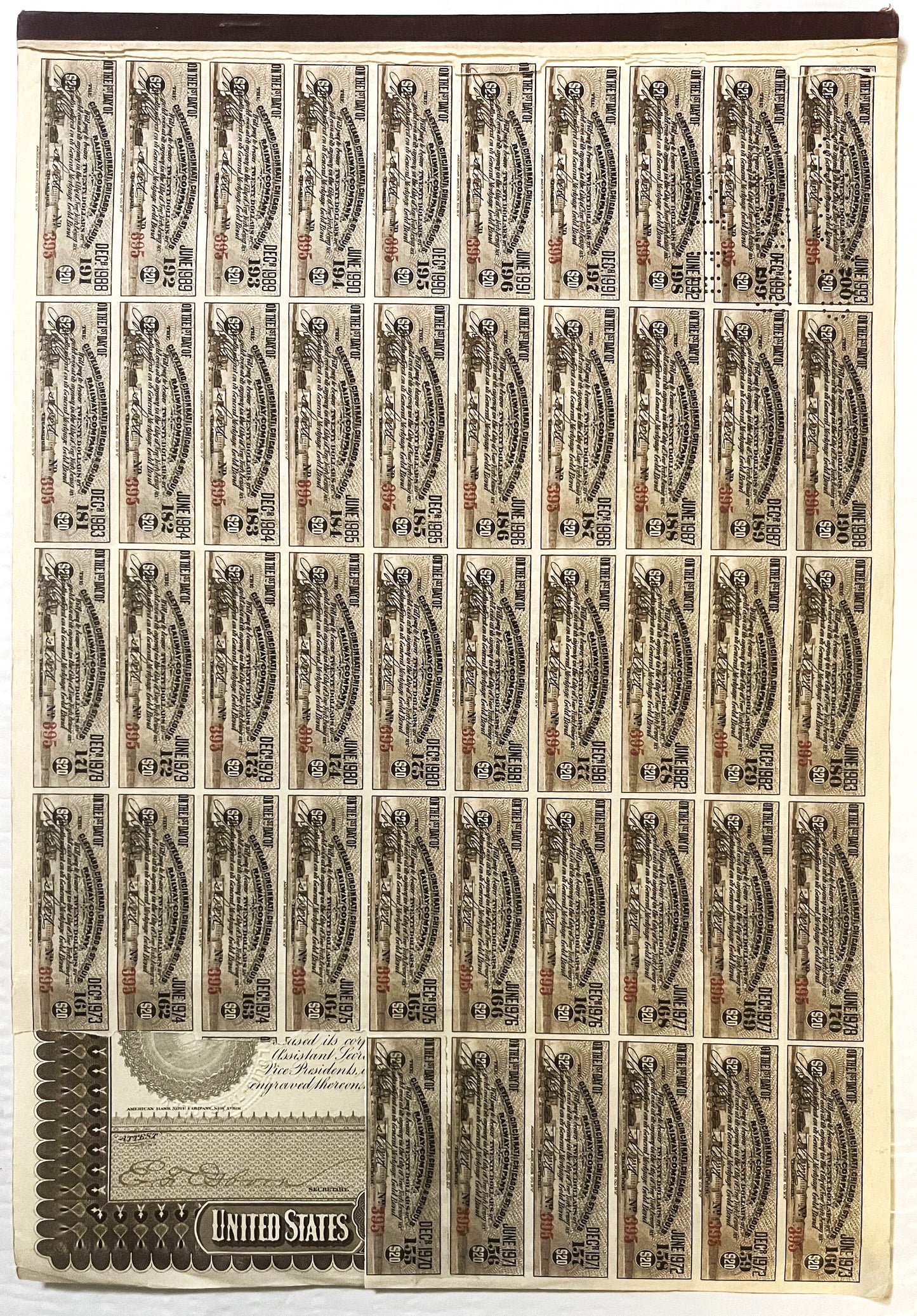 Uncut sheet of approximately 50 vintage $1,000 railroad bond certificates with ornate engravings and attached coupons, displa