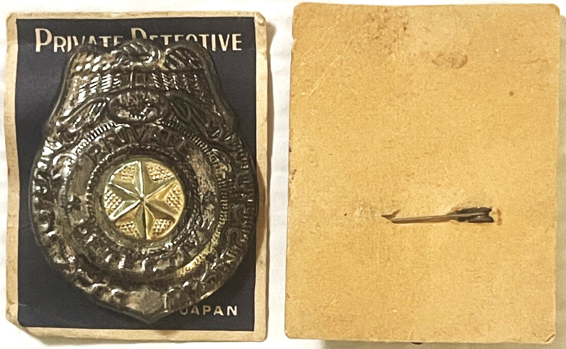 Vintage tin detective badge with eagle emblem on black card labeled "Private Detective" and "Japan," shown front and back on 