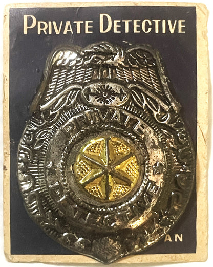 Vintage metal detective badge with eagle, star, and gold center on black card printed "Private Detective