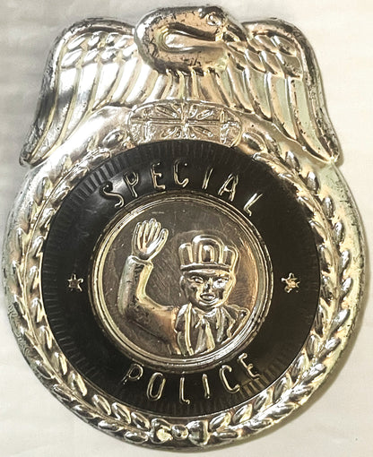 Vintage metal Special Police badge with eagle emblem on top, black circular center showing uniformed officer with raised fist