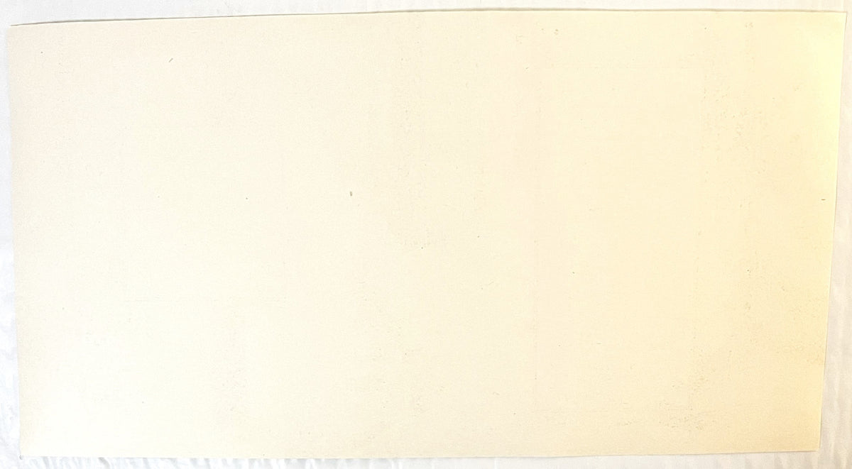Blank cream-colored vintage water label with faded text, photographed against light background