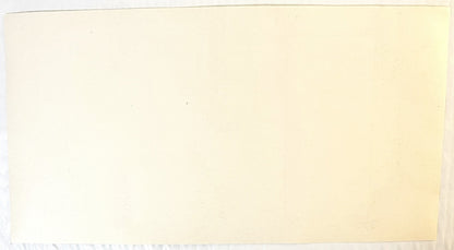 Blank cream-colored vintage water label with faded text, photographed against light background