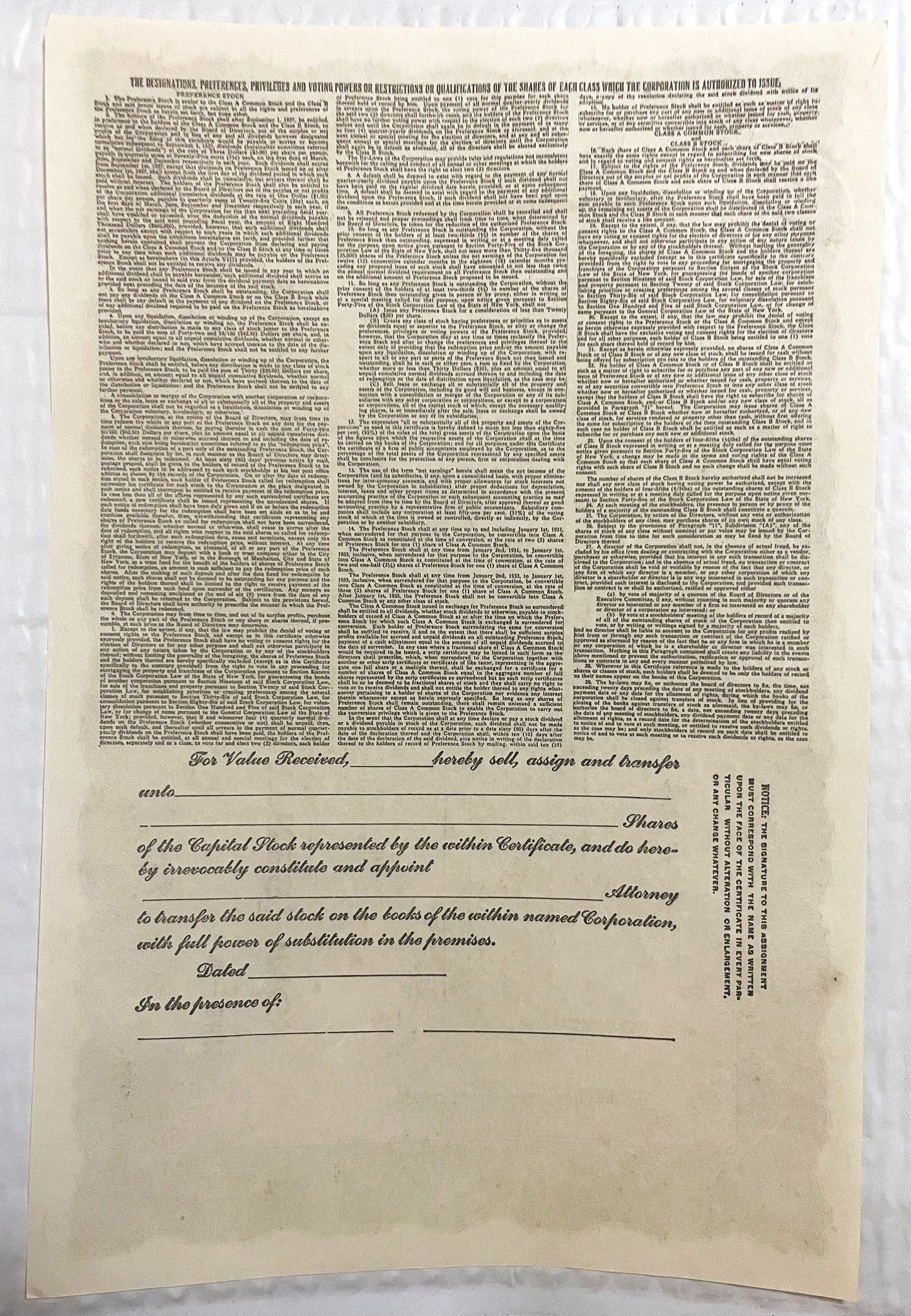 Cream-colored stock certificate page with dense printed text at top and blank transfer form below with signature lines and da