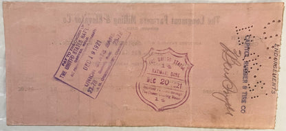 Aged pink voucher check from 1921 with purple stamps and handwritten signatures, showing United States National Bank seal dat