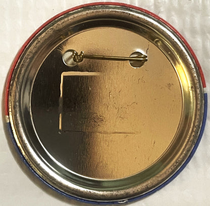 The reverse of the large button: a plain brass-toned back inside the rolled red, white and blue rim, with the pin across the top.