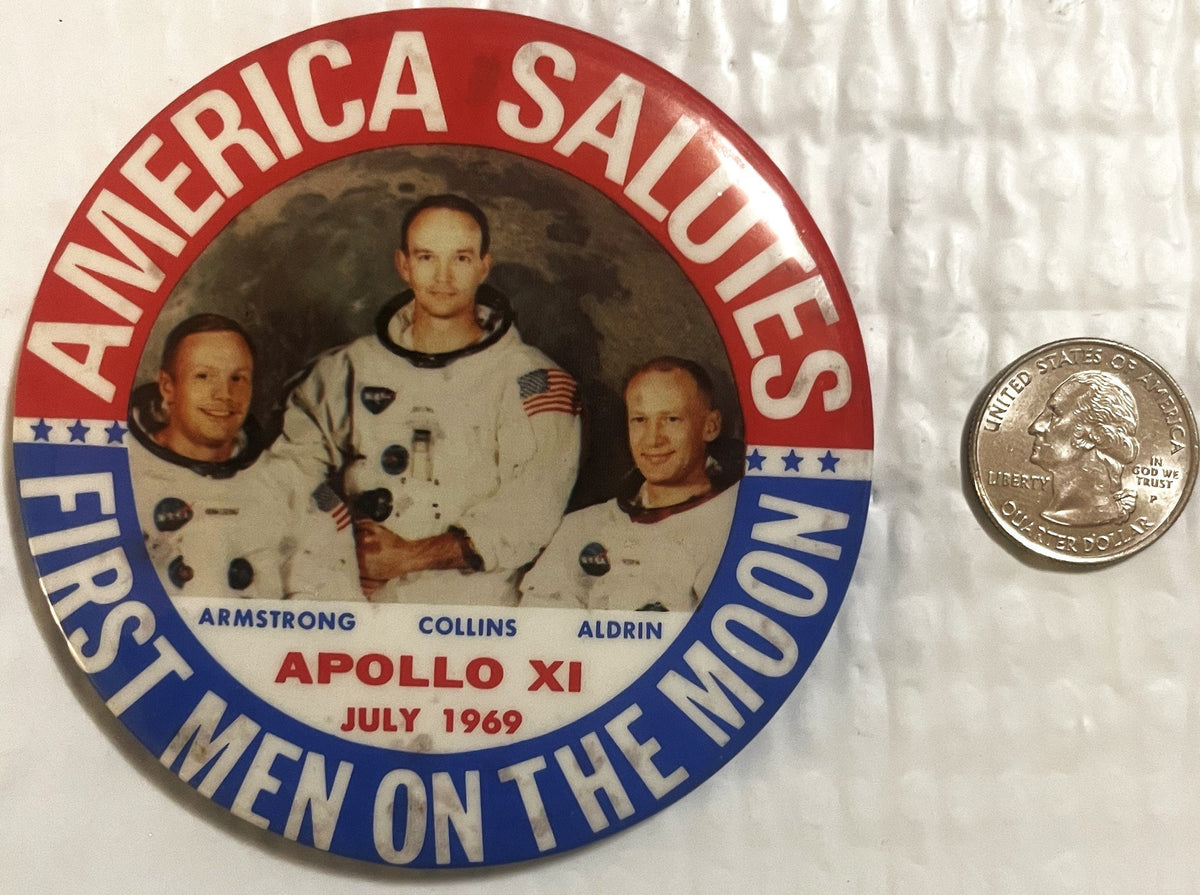 The large button beside a US quarter for scale; it stands roughly three and a half times the coin across.