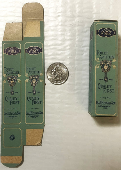 Antique JBL green toilet articles boxes with decorative woman's head logo, displayed flat and upright next to a quarter for s