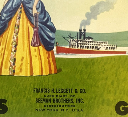 Vintage steamboat can label showing woman in yellow and blue dress viewing paddlewheel riverboat, printed by Francis H. Legge