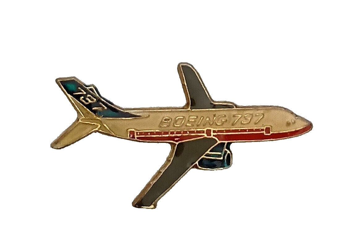 Vintage Boeing 737 enamel lapel pin with gold, red, and dark blue coloring, shown at angle against white background