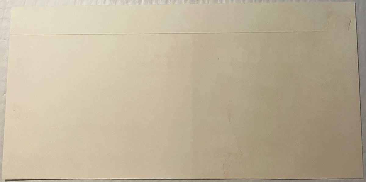 Blank cream-colored envelope or card with fold line at top, photographed flat against white surface