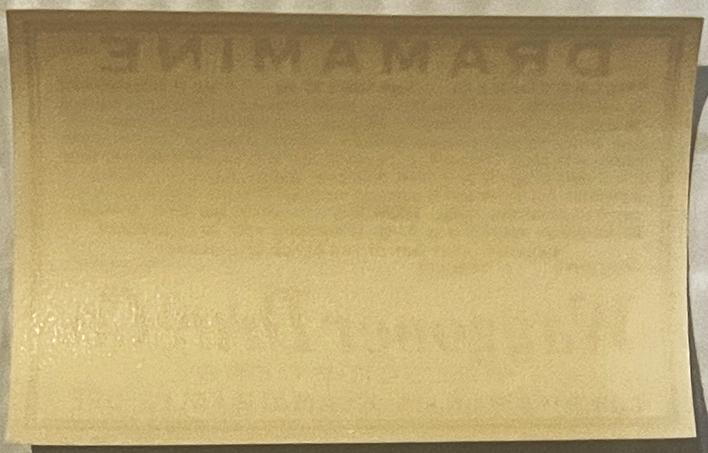 Cream-colored vintage Dramamine label on dark background, front view showing faded printing