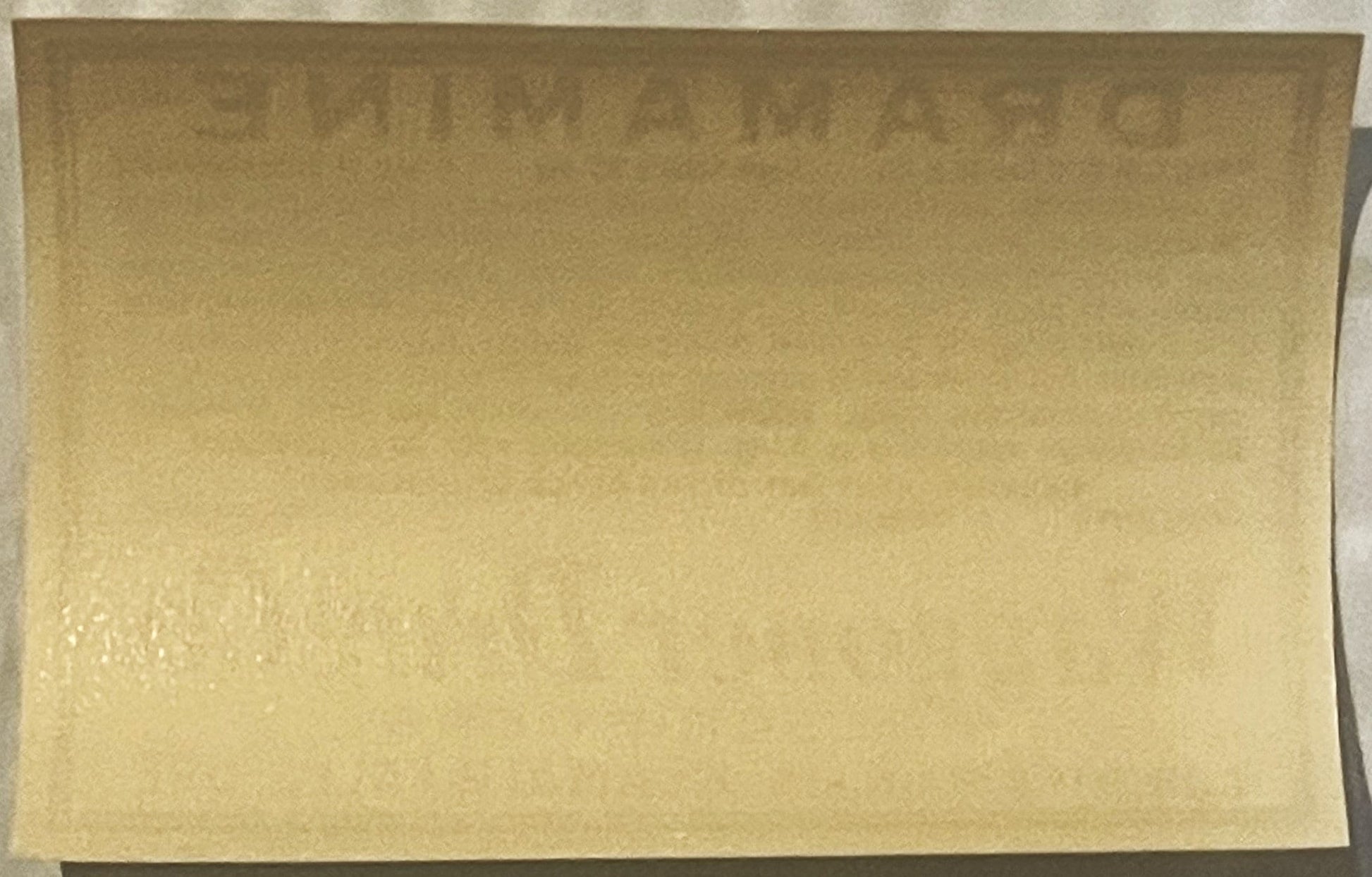 Cream-colored vintage Dramamine label on dark background, front view showing faded printing