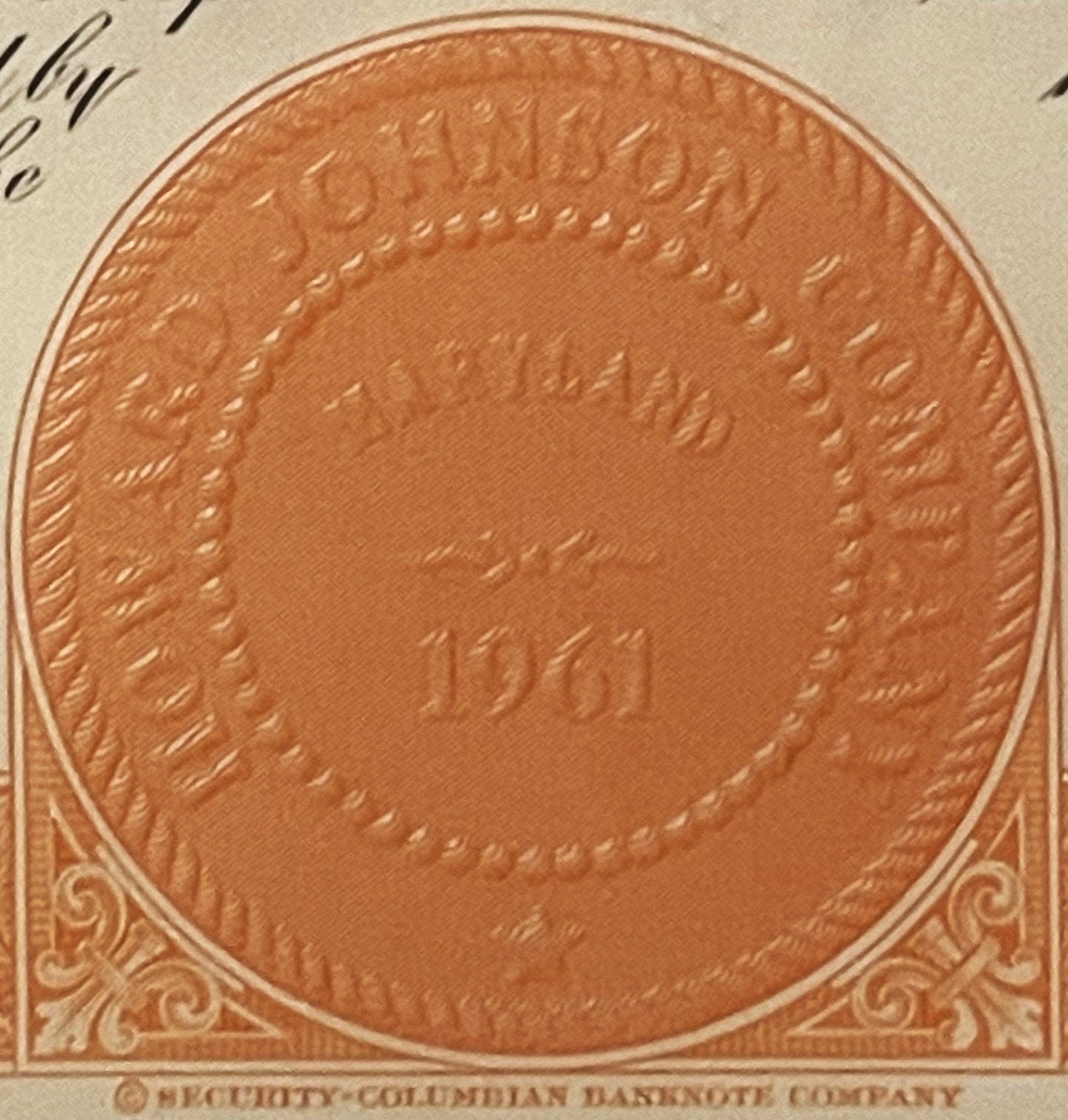 Close-up of embossed orange stock certificate detail showing ornate corner scrollwork and circular central medallion with "Se