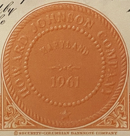 Close-up of embossed orange stock certificate detail showing ornate corner scrollwork and circular central medallion with "Se