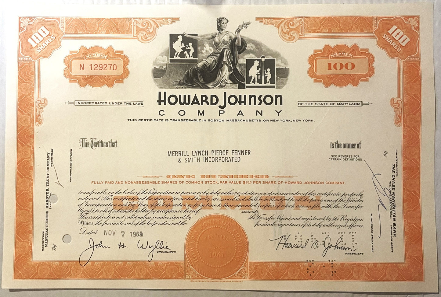 Orange and cream stock certificate for Howard Johnson Company, 100 shares, with ornate borders and co