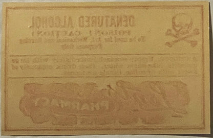 Faded tan vintage poison label with embossed text and decorative border, showing "Denatured Alcohol" and "Lents Pharmacy Port