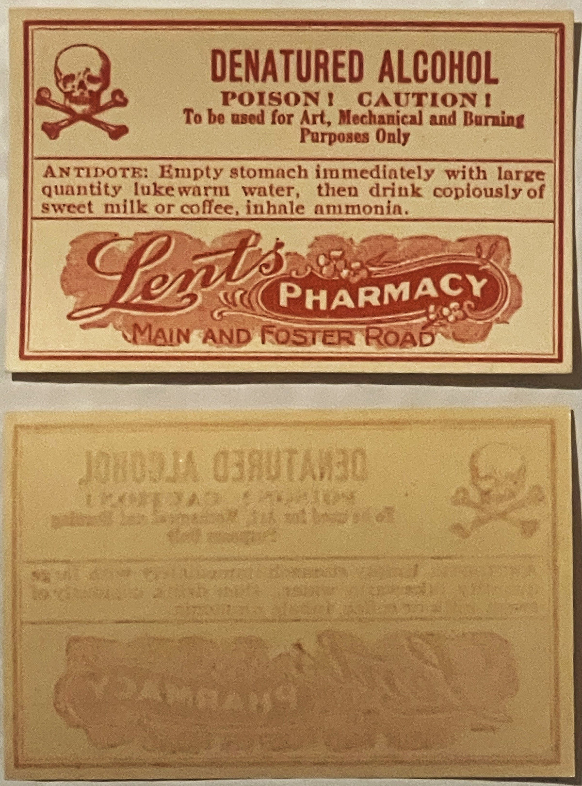 Vintage denatured alcohol poison label from Lents Pharmacy with skull and crossbones symbol, front and back sides shown on ta