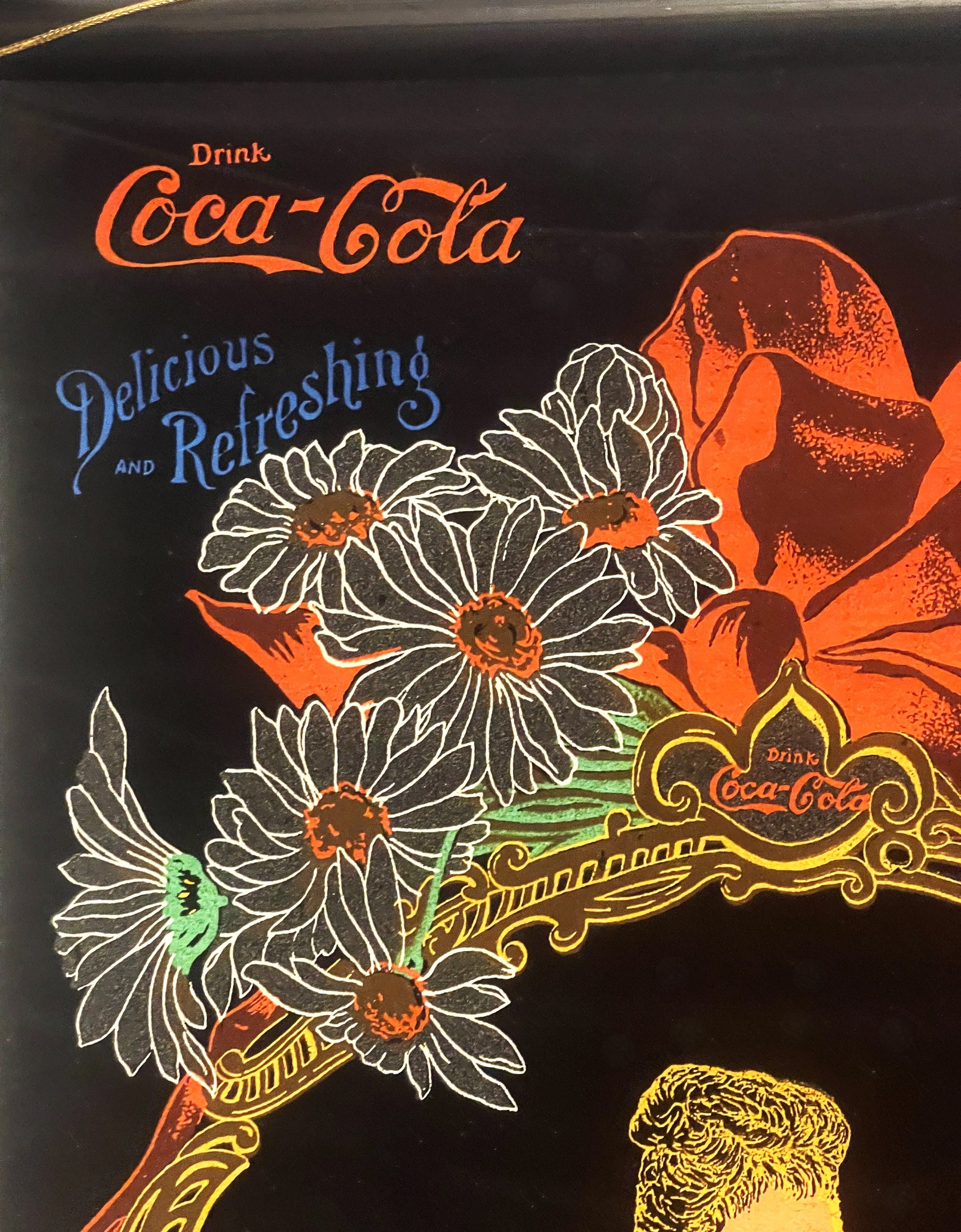 Vintage Coca-Cola cloth calendar scroll with orange, white, and gold lettering on black background, featuring daisies and dec