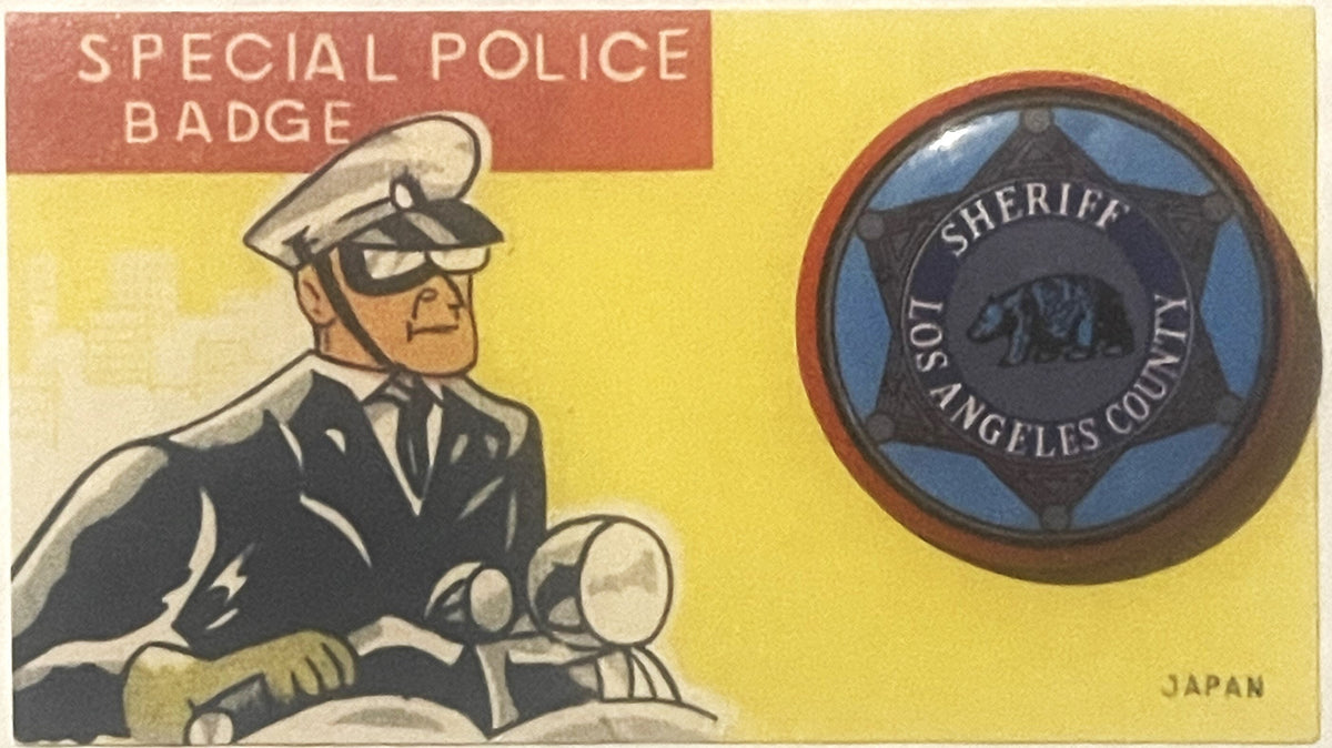 Vintage tin litho card showing cartoon police officer on left and circular sheriff badge on right, yellow background, marked 