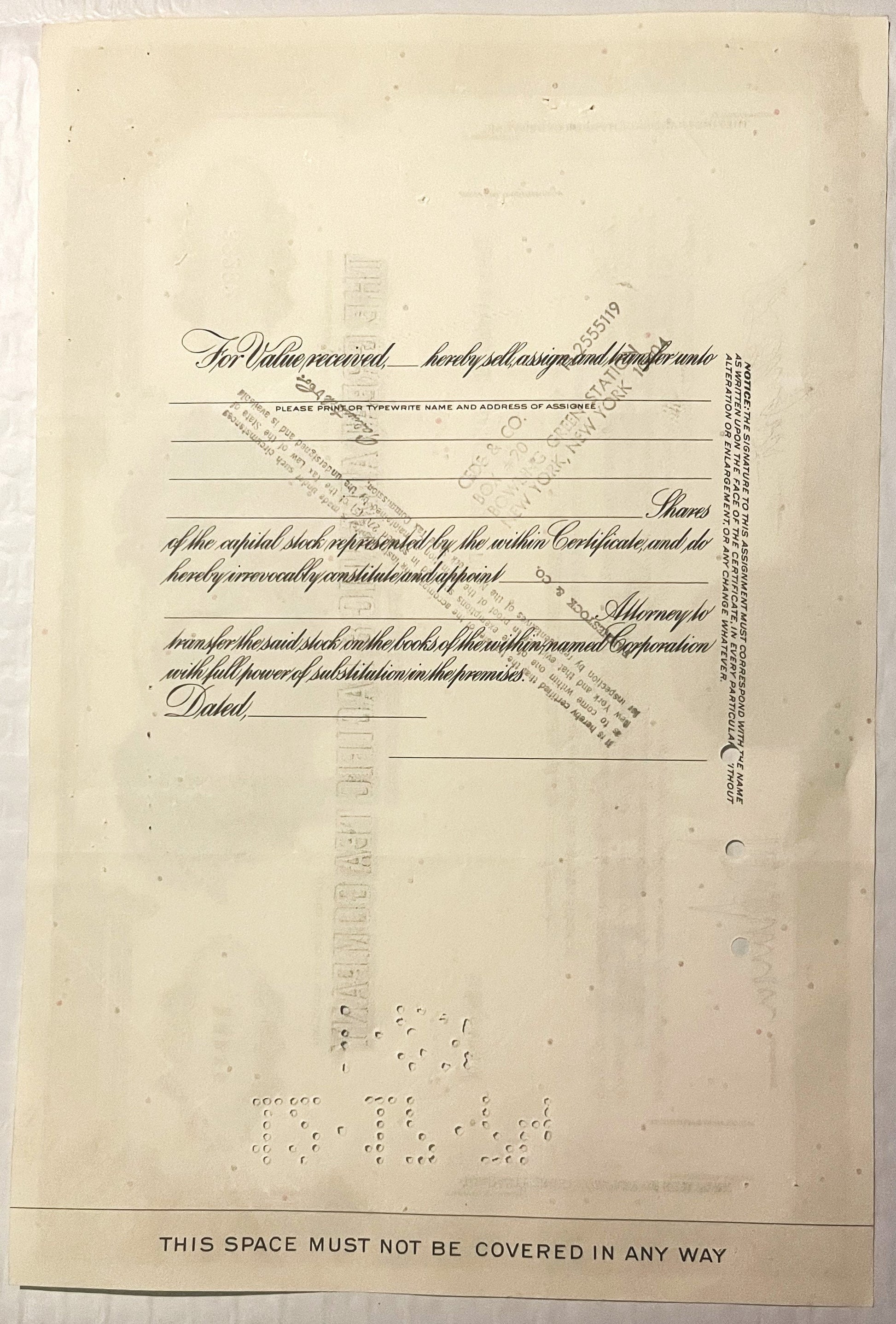 Yellowed vintage stock certificate form with ornate cursive text, blank lines for assignee information, and "THIS SPACE MUST 