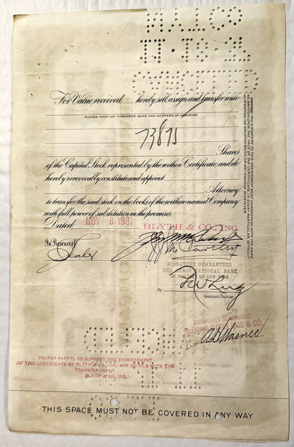 Aged stock certificate from with handwritten signatures, printed text, and perforated holes along edges, displayed flat