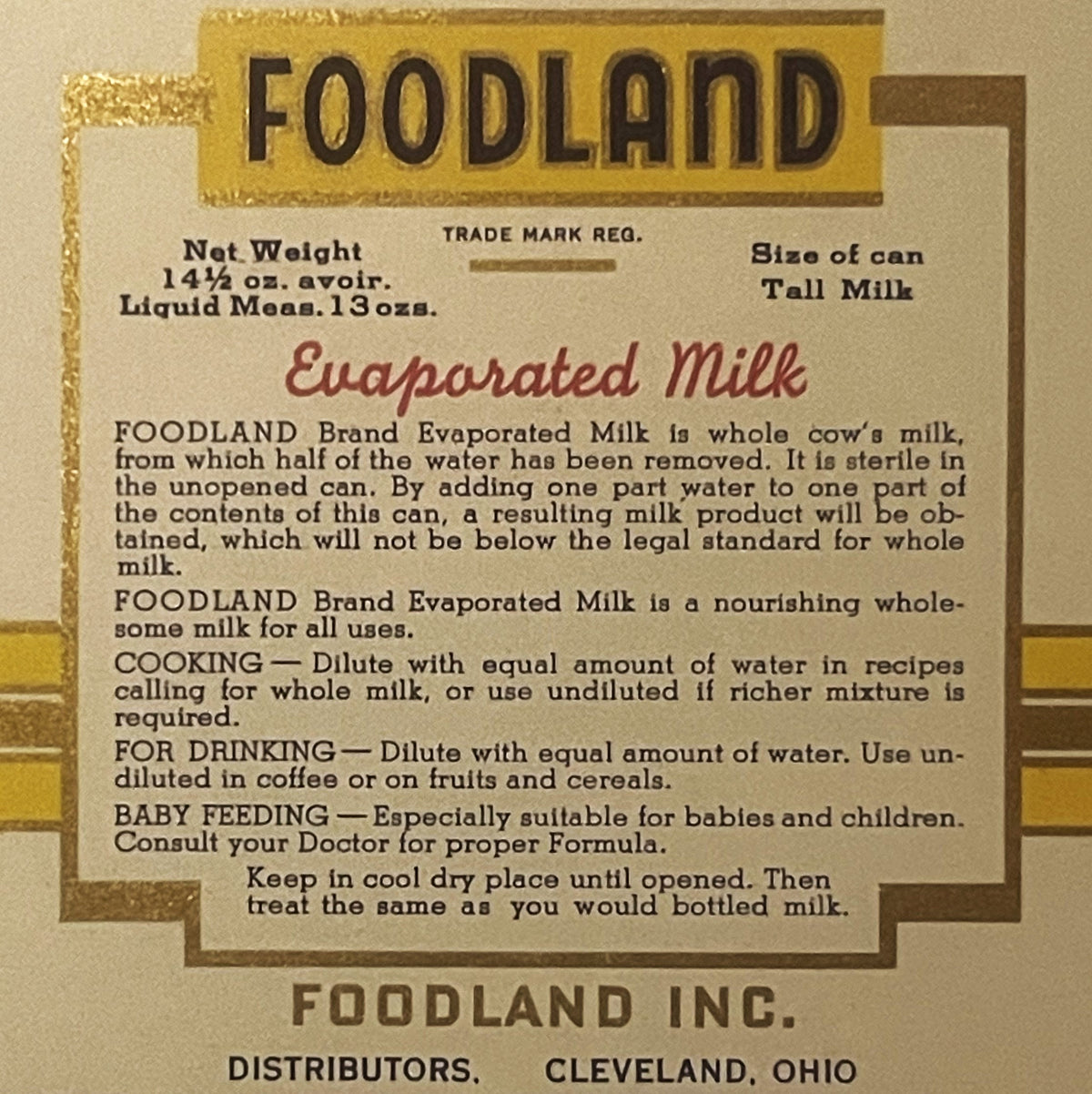 Antique Foodland evaporated milk label, tan and gold, featuring product information and usage instructions for cooking, drinking, and baby feeding. Distributed by Foodland Inc., Cleveland, Ohio.