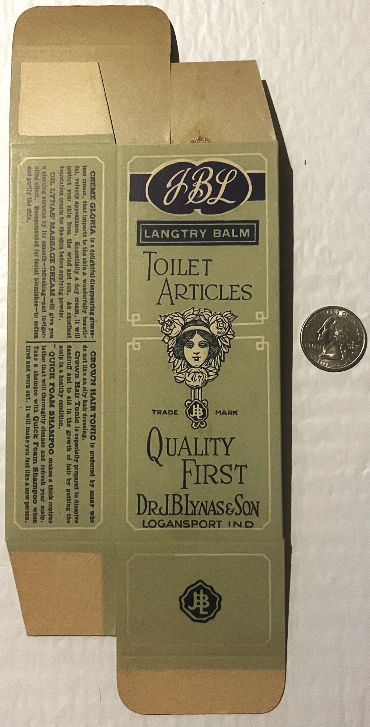 Flat lay of vintage JBL Langtry Balm toilet articles box from Logansport, Indiana, shown unfolded with quarter coin for scale