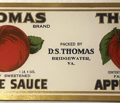 Antique Thomas brand apple sauce can label from Bridgewater, VA, showing red apples with green leaves, gold lettering, and text reading "Packed by D.S. Thomas," 1 lb. 4 oz. size.