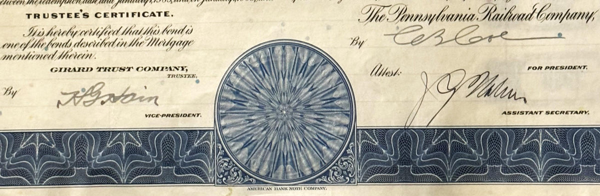 Close-up of vintage Pennsylvania Railroad bond certificate header with blue circular vignette, ornate decorative borders, and
