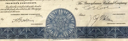 Close-up of vintage Pennsylvania Railroad bond certificate header with blue circular vignette, ornate decorative borders, and