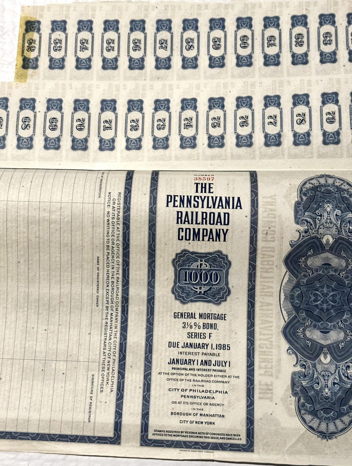 Vintage Pennsylvania Railroad $1000 bond certificate with ornate vignette, shown flat with uncut sheet detail