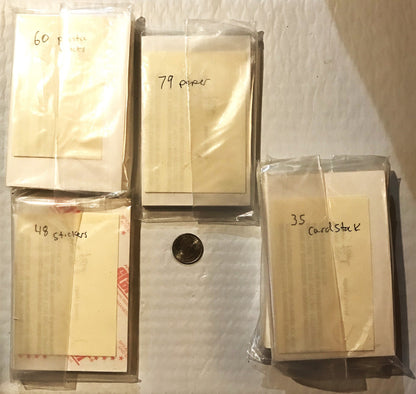 Four sealed plastic packages of vintage Coca-Cola promo cards labeled with handwritten quantities (60, 79, 48, 35), with a pe
