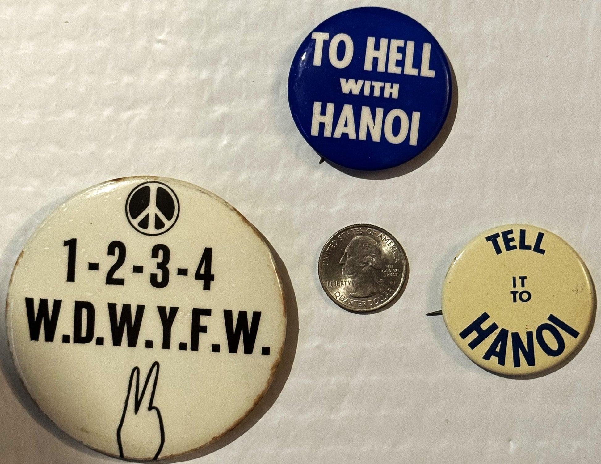 Three vintage protest pinback buttons and a quarter for scale on white background; largest cream button reads "1-2-3-4 W.D.W.