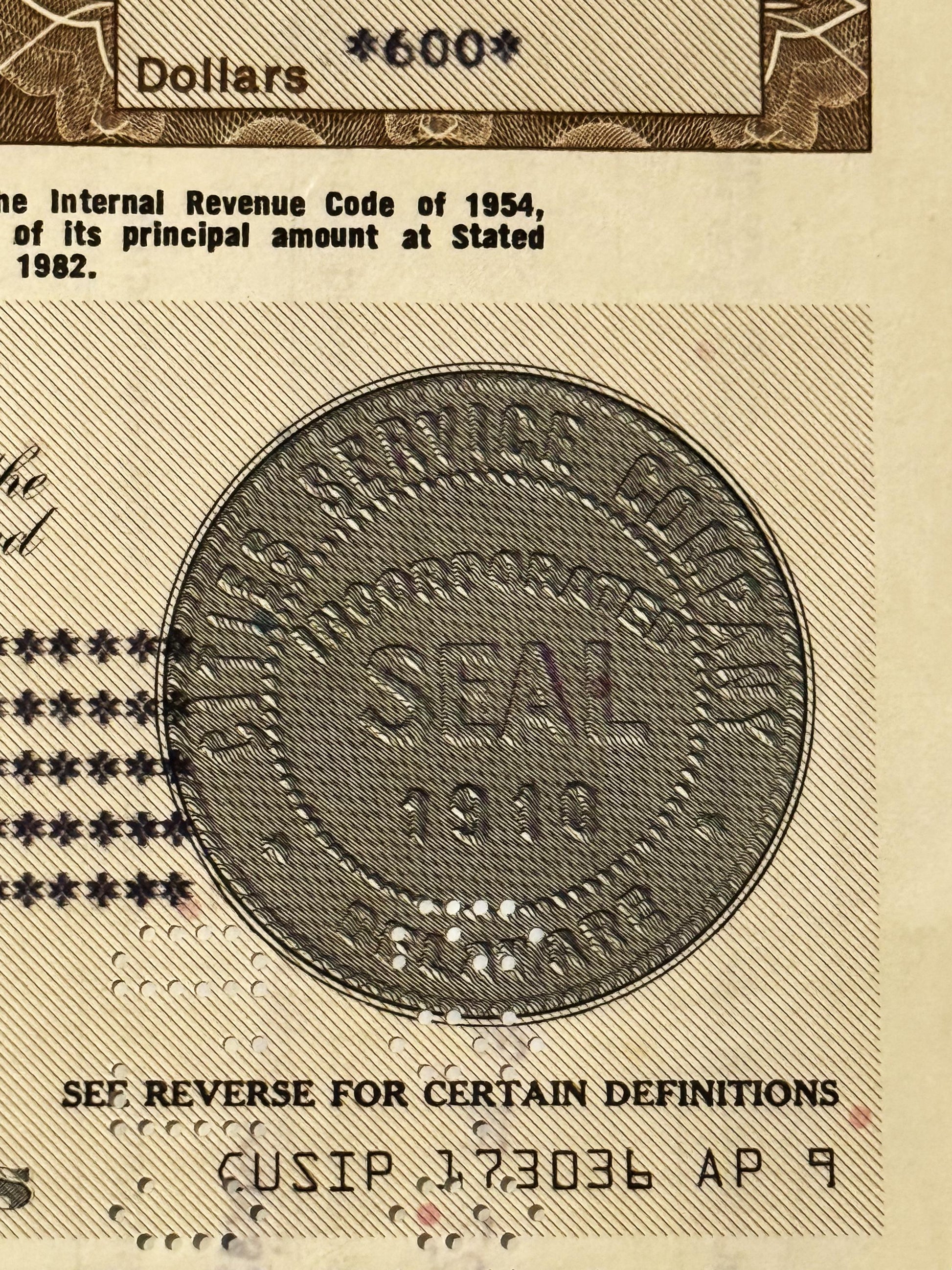 Close-up of vintage stock certificate showing circular seal with eagle emblem and text referencing Internal Revenue Code of 1