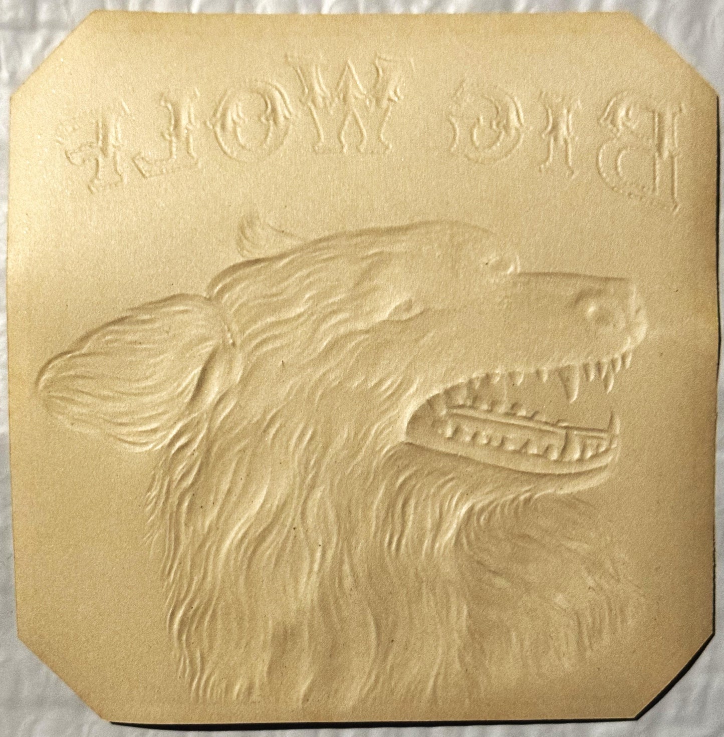 Cream-colored embossed cigar label featuring a wolf's head in profile with detailed fur texture and bared teeth, text visible