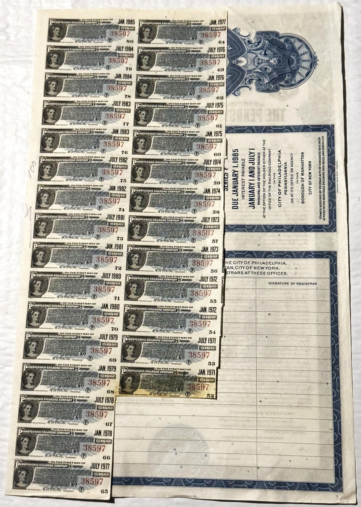 Vintage Pennsylvania Railroad bond certificate with multiple coupons dated 1971-1985, showing portrait vignette