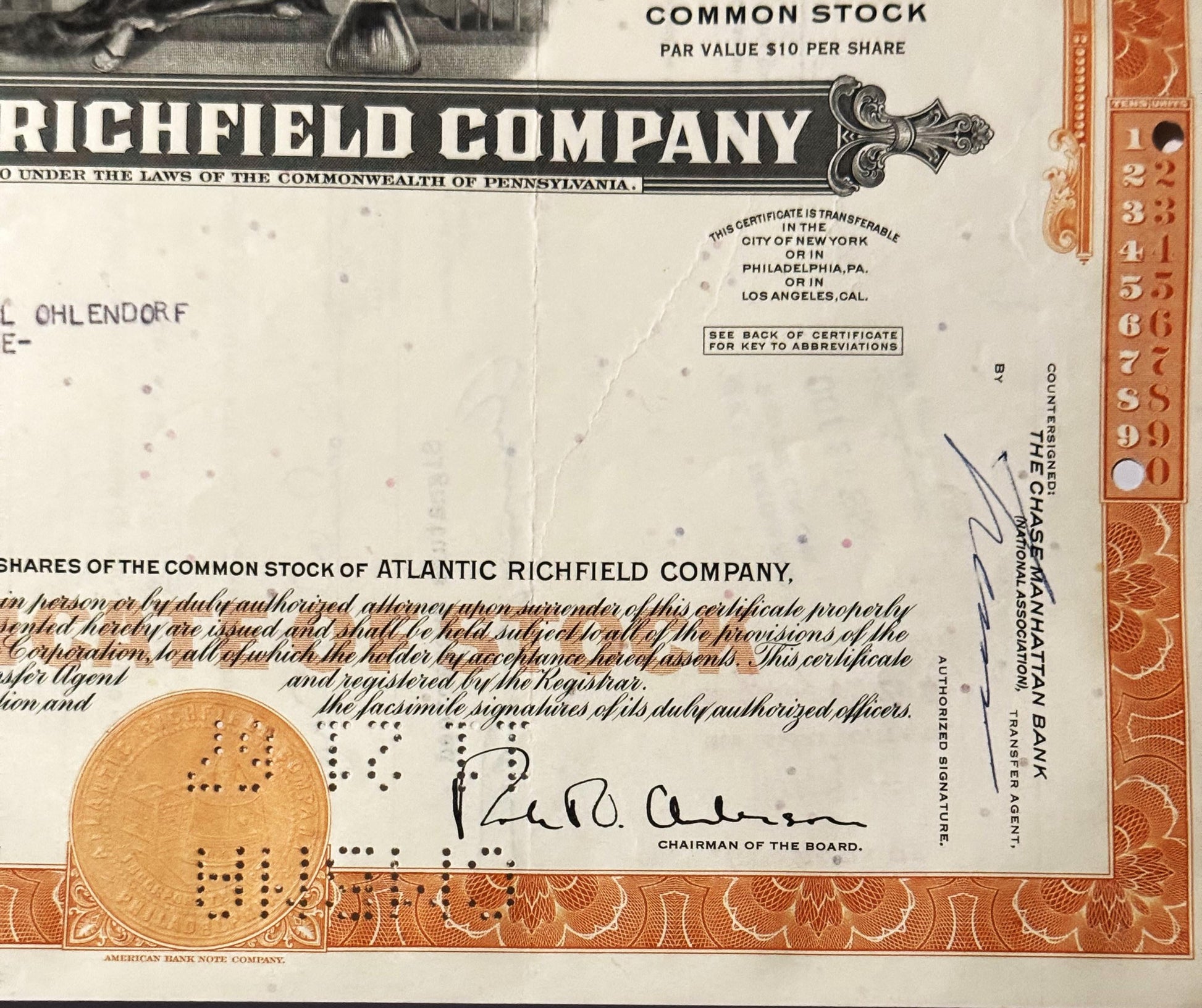 Vintage Atlantic Richfield Company stock certificate with orange decorative border, gold seal, and chairman's signature visib