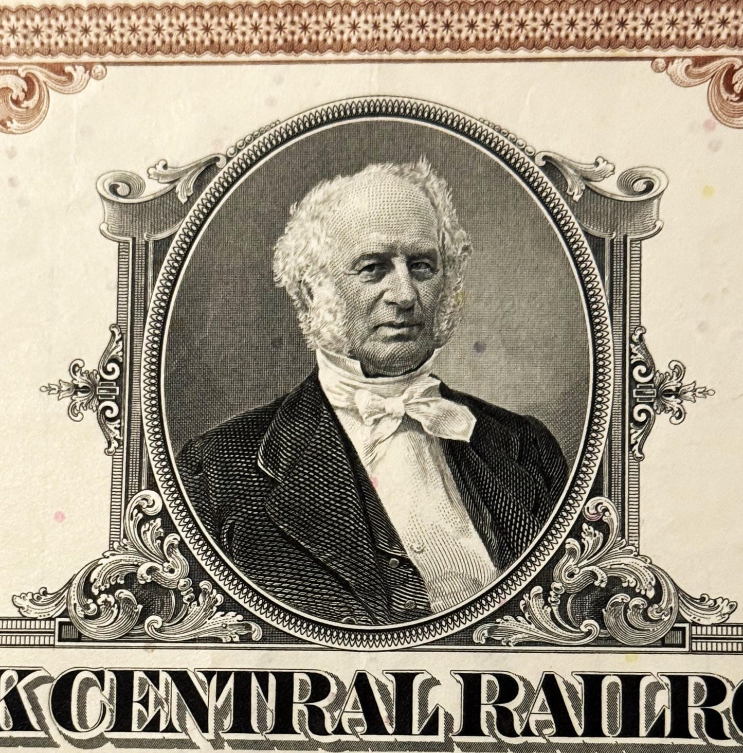 Engraved portrait of a bearded man in formal 19th-century attire within ornate oval frame, with "CENTRAL RAILROAD" text visib