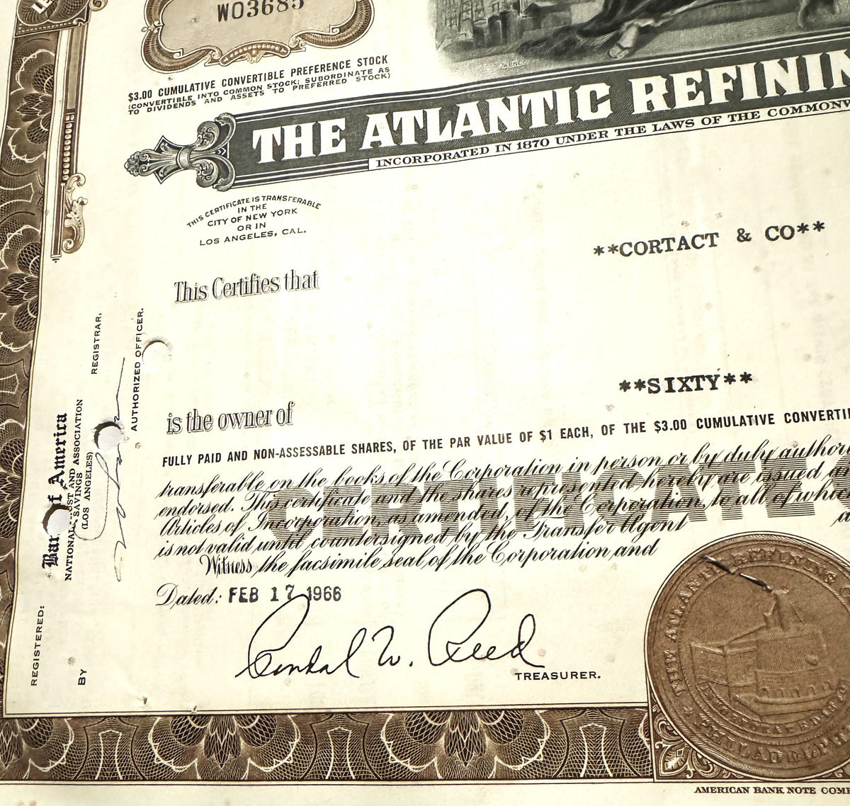 Atlantic Refining Company stock certificate with decorative border, signature, and penny for scale