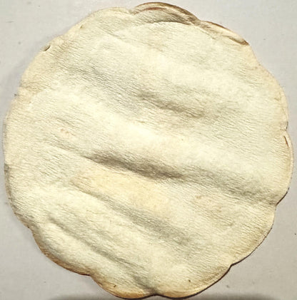 Cream-colored circular cloth coaster with embossed diagonal ridged texture pattern and darkened edges, photographed flat agai